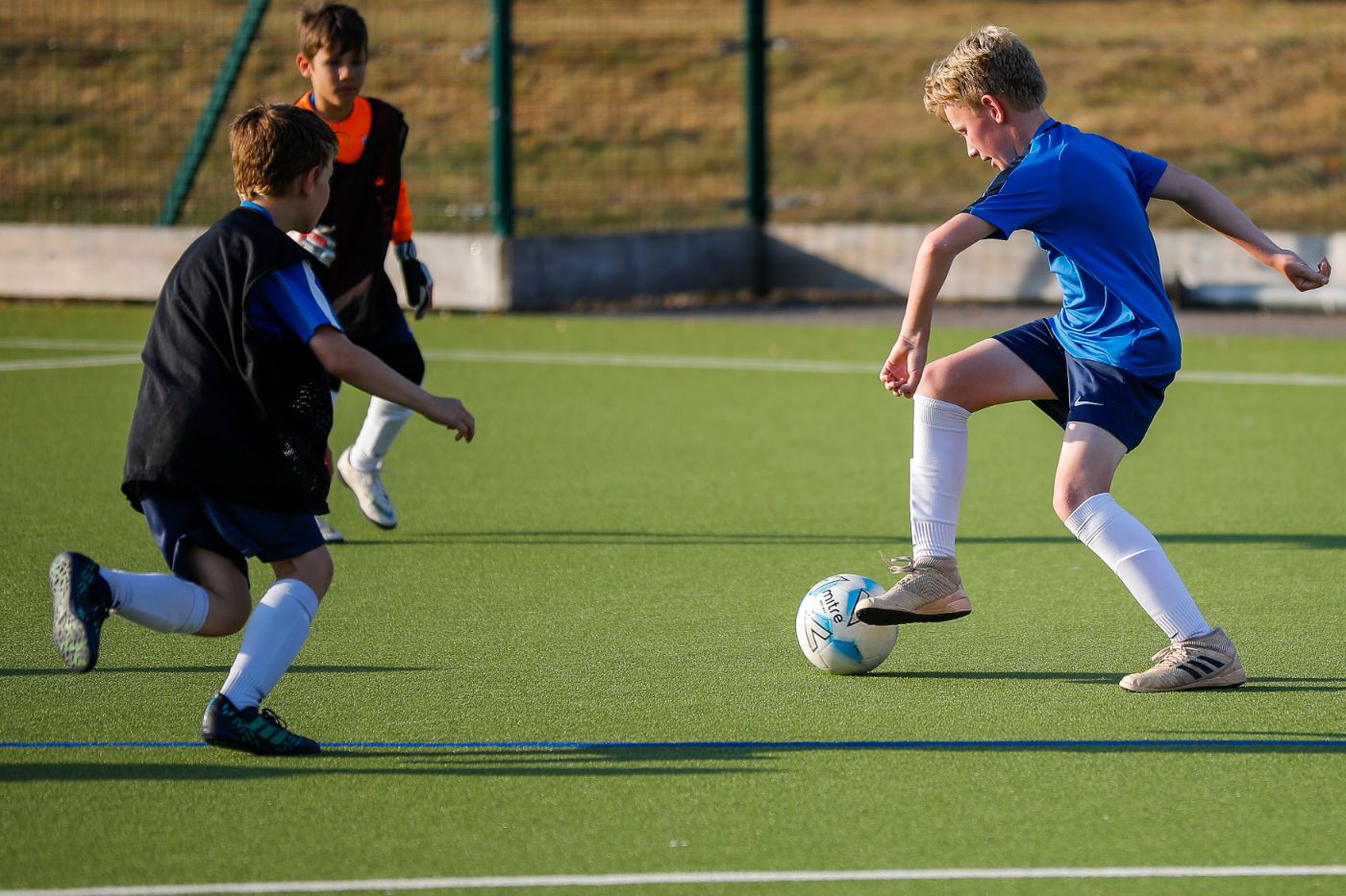 Student dribbling in football practice